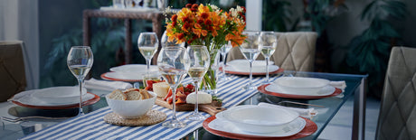 Mesa de comedor con vajilla servida y copas con champaña