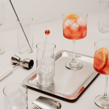 Copa de cóctel y vaso con bebida del set Cocktails Tu Bar