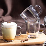 Mug de vidrio London con bebida tipo latte con espuma y anís en mesa, junto a tazas apiladas