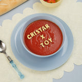 Plato hondo de la vajilla Stylo Blue colección cristar x toy, con crema de tomate servida.