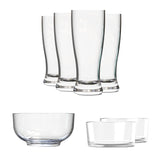 Vasos altos y tazones de vidrio transparente alineados en composición limpia sobre fondo blanco