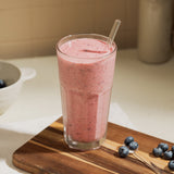 Un vaso de vidrio Lisboa con batido de frutos rojos sobre superficie de madera