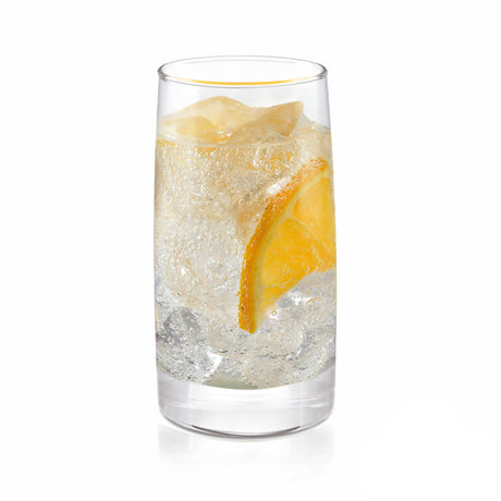 Vaso de vidrio alto con bebida, hielo y rodaja de naranja en su interior sobre fondo claro