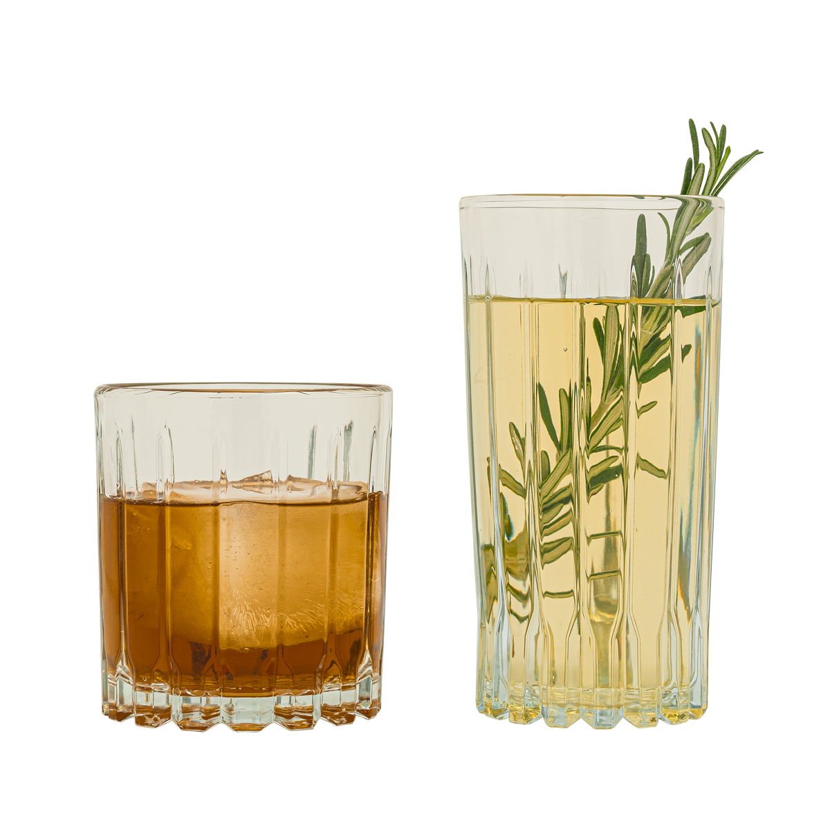 Dos vasos de vidrio Bali. Uno corto con bebida ámbar oscura, y otro alto con líquido claro y una ramita de romero como decoración.