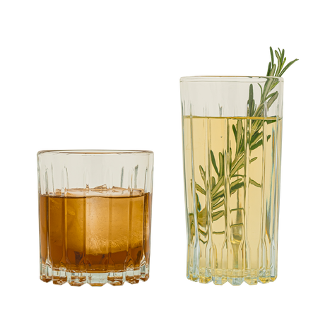 Dos vasos de vidrio Bali. Uno corto con bebida ámbar oscura, y otro alto con líquido claro y una ramita de romero como decoración.
